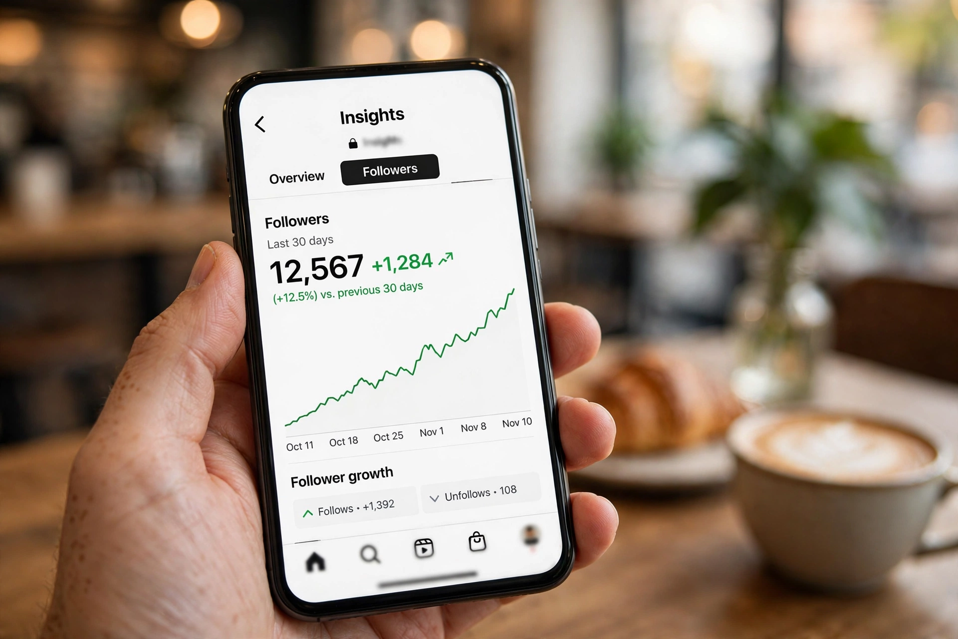 Compare Instagram followers over time: hand holding a phone showing a follower growth chart